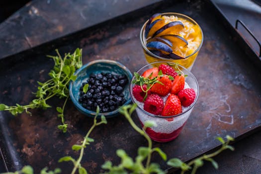 Fresh berry and fruit parfaits beautifully presented on a rustic tray.