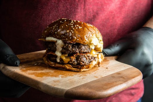 Mouth-watering double cheeseburger with bacon on a wooden board, perfect for food lovers.